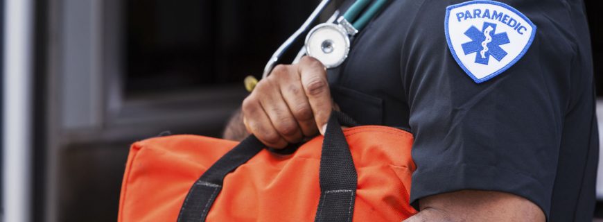 Close up of male paramedic (40s, mixed race African American and Hispanic) holding medical bag.